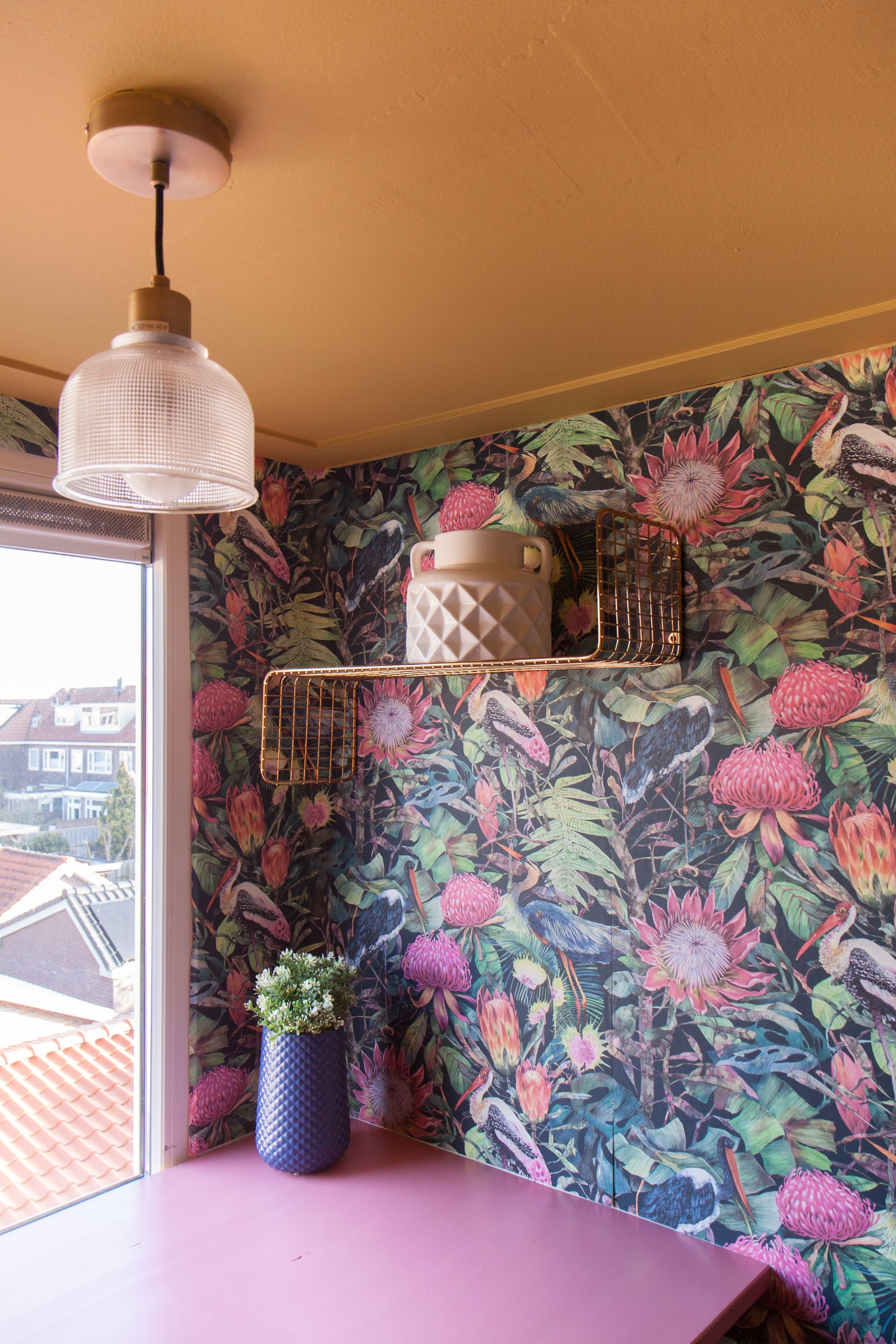 Botanisch behang, bloempot, roze plank en gouden wandplank.