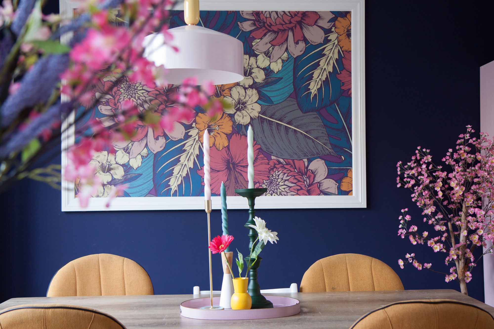 De kleur Geldersblauw Strak in de eetkamer met grote poster, eettafel, 4 stoelen en kaarsen.
