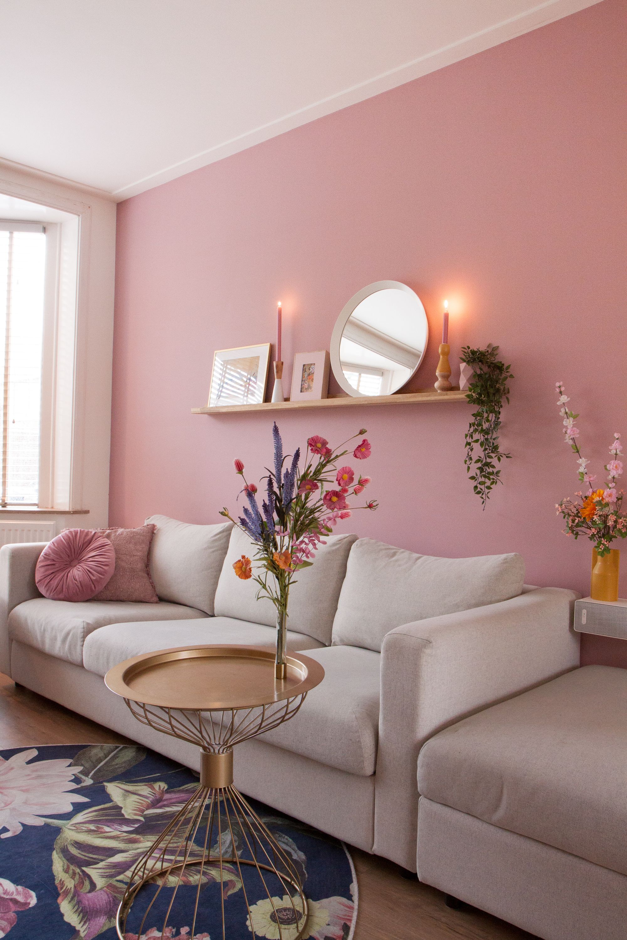 De kleur Mild Berry op de woonkamermuur, Vimle bank van Ikea, gouden bijzettafel, wandplank met decoratie.