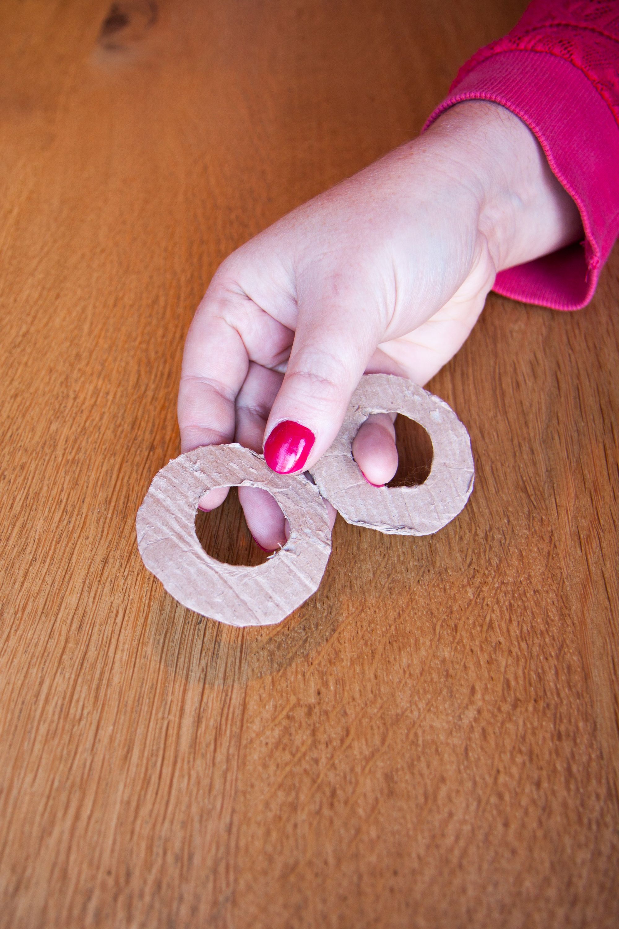 Roze nagellak, twee basisstukjes karton voor de pompons