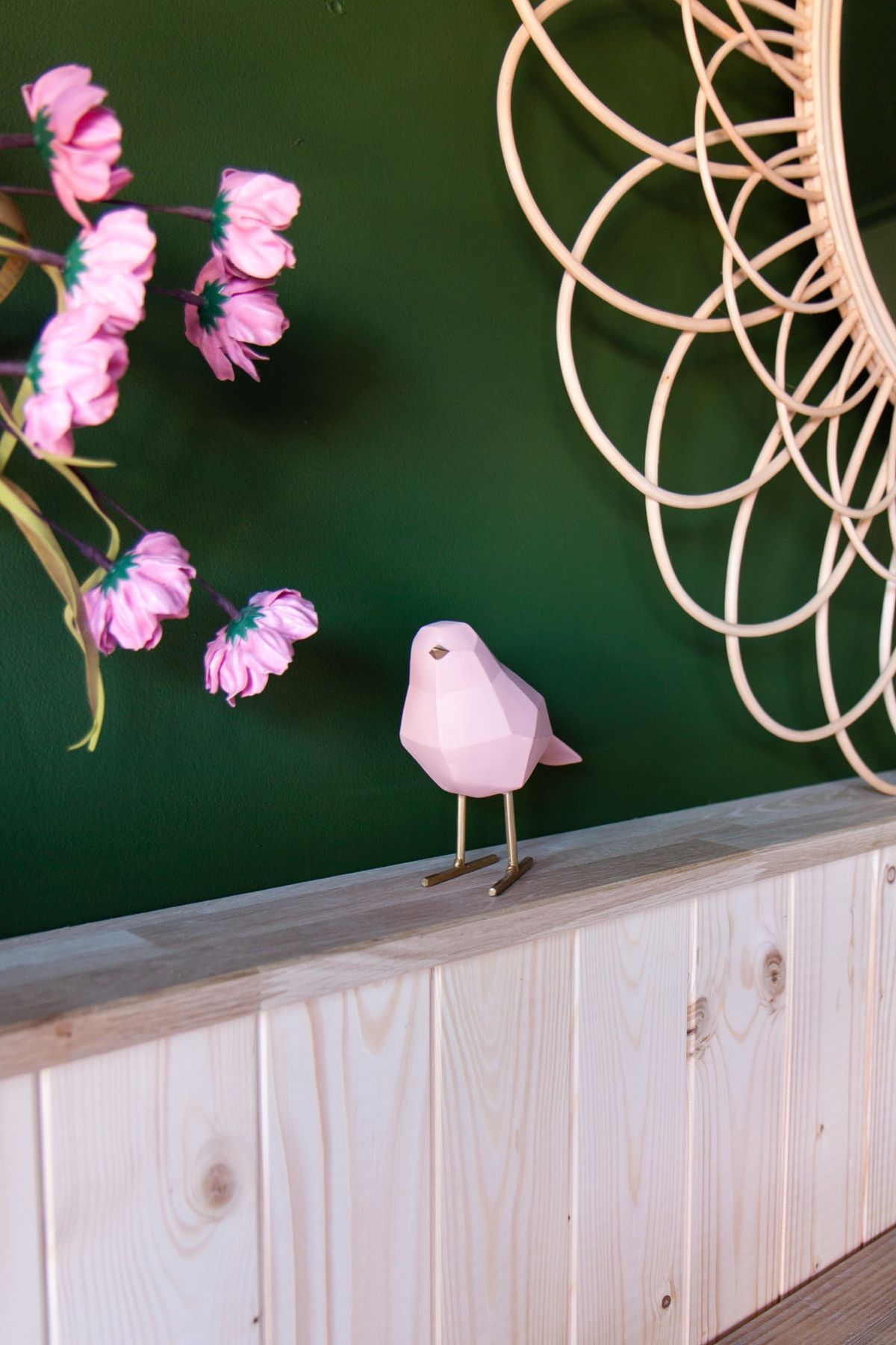 Roze vogeltje op de lambrisering voor de groene muur
