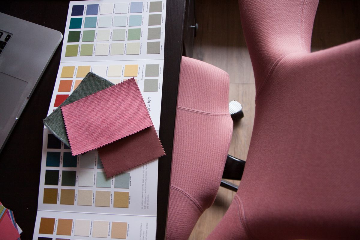 Interieurstylist werkplek met kleurkaartjes en een bureaustoel