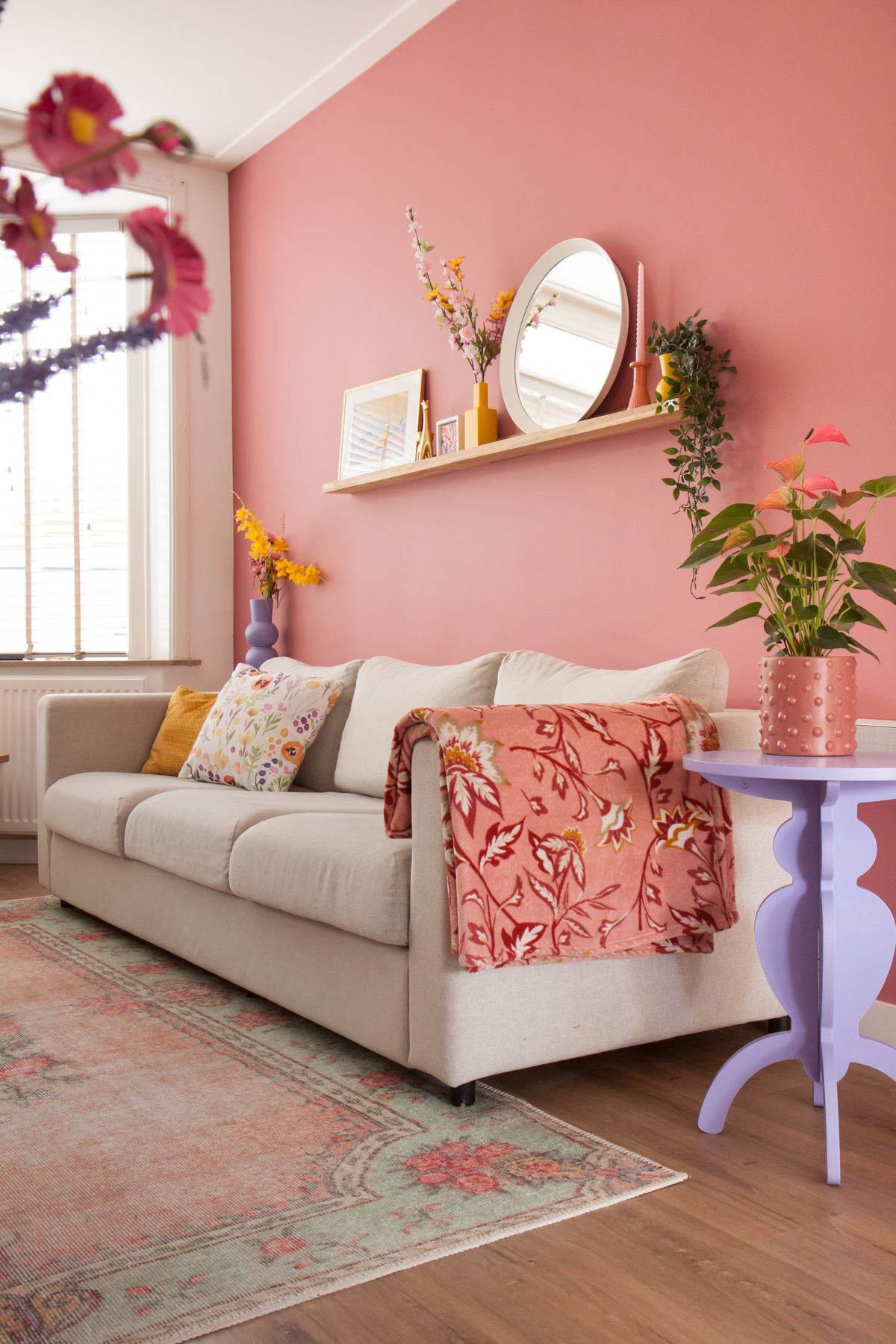 Haal de zomer in huis met deze roze muurverf in de woonkamer